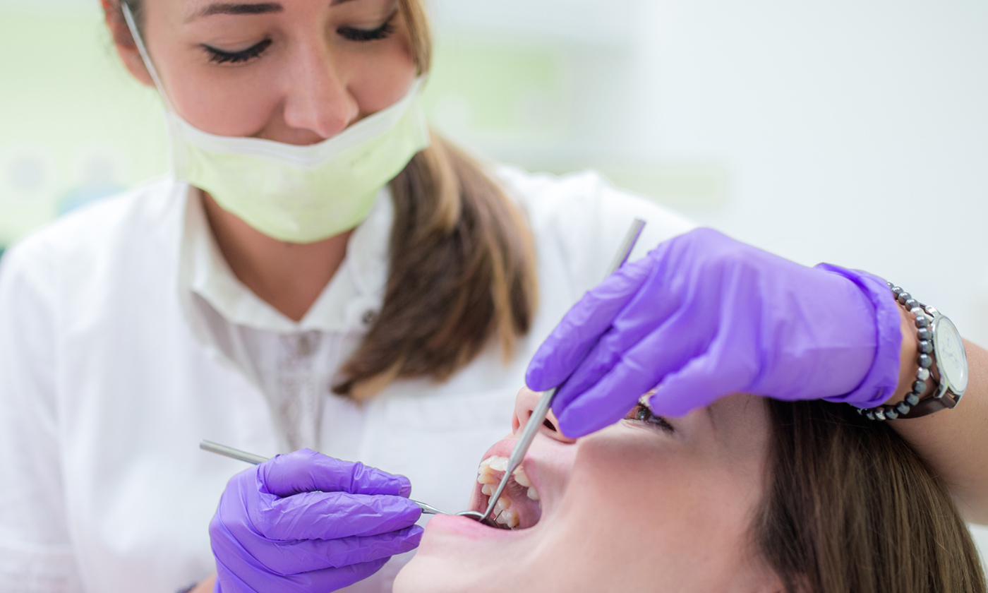 Dentist inspecting patient teeth